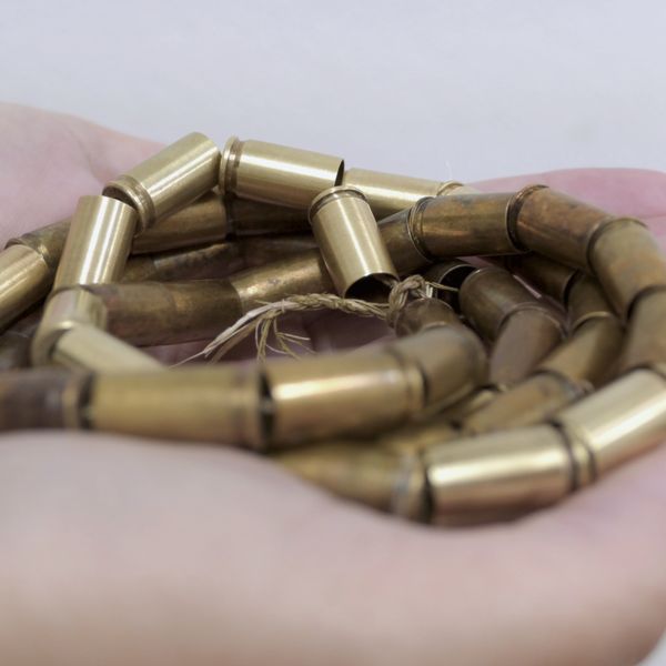 Brass Bullet casings threaded together and held in a persons palm
