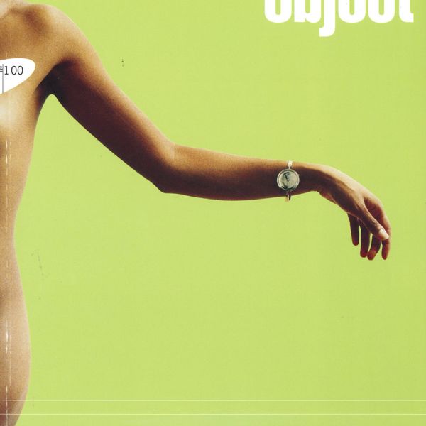 Magazine cover with nude female figure against a green backdrop, the model wears a bracelet