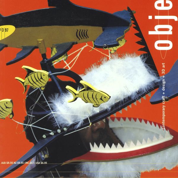 Magazine cover with a make figure wearing a Shark Dance Mask on a red background