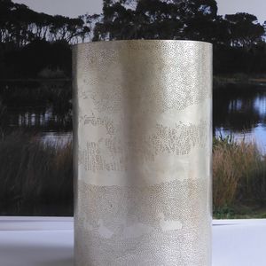 Photo of a silver cylinder decorated with small holes.