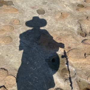A shadow of the artist is cast onto a rock